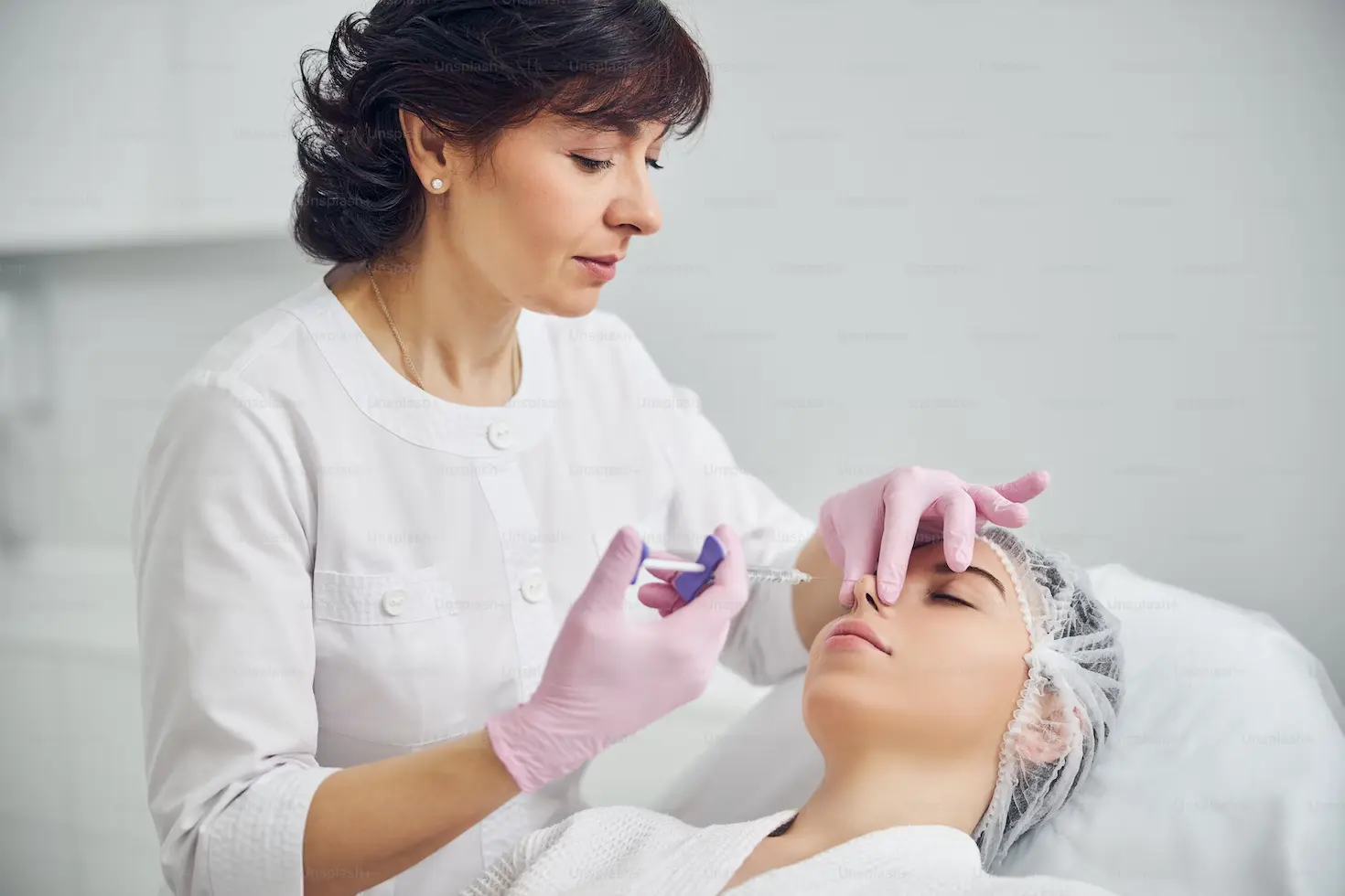 Professional therapist using a syringe and holding patient nose while applying liquid medicine